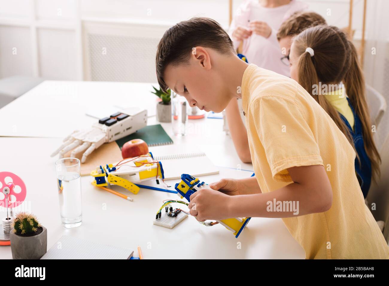 Modernes Technologiekonzept. Junge, der Roboter in der Stemm-Klasse kreiert Stockfoto