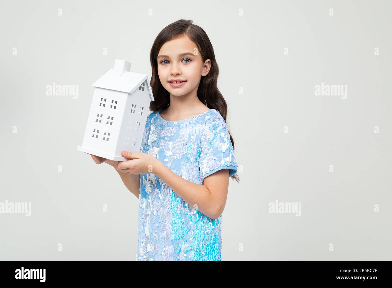 Teenager-Mädchen mit einer Papiertüte zu Hause auf weißem Hintergrund mit Kopierraum. Unbewegliches Eigentum Stockfoto