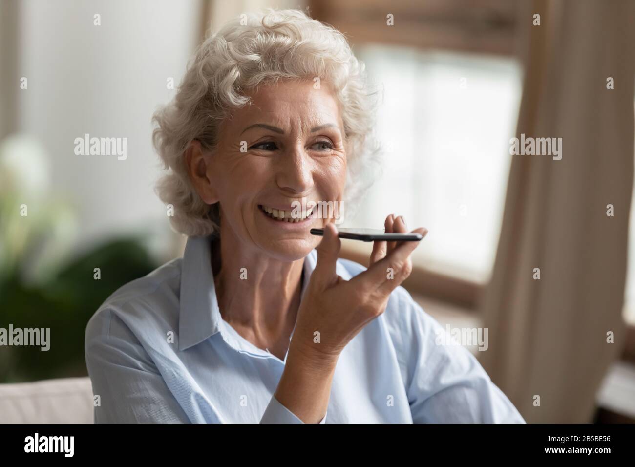 Moderne Frau zeichnet Sprachnachrichten auf der Zelle auf Stockfoto