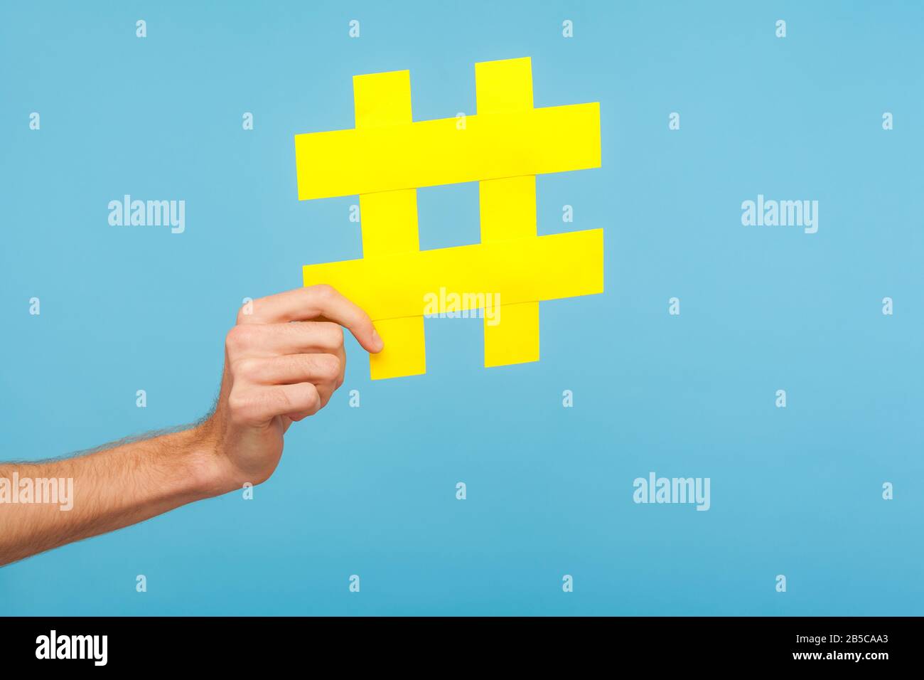 Nahaufnahme der männlichen Hand mit großem gelben Hash-Zeichen, Hashtag-Symbol für Internet-Trends und beliebte Blogs, Empfehlung, Social Media-Inhalte zu folgen. Stockfoto