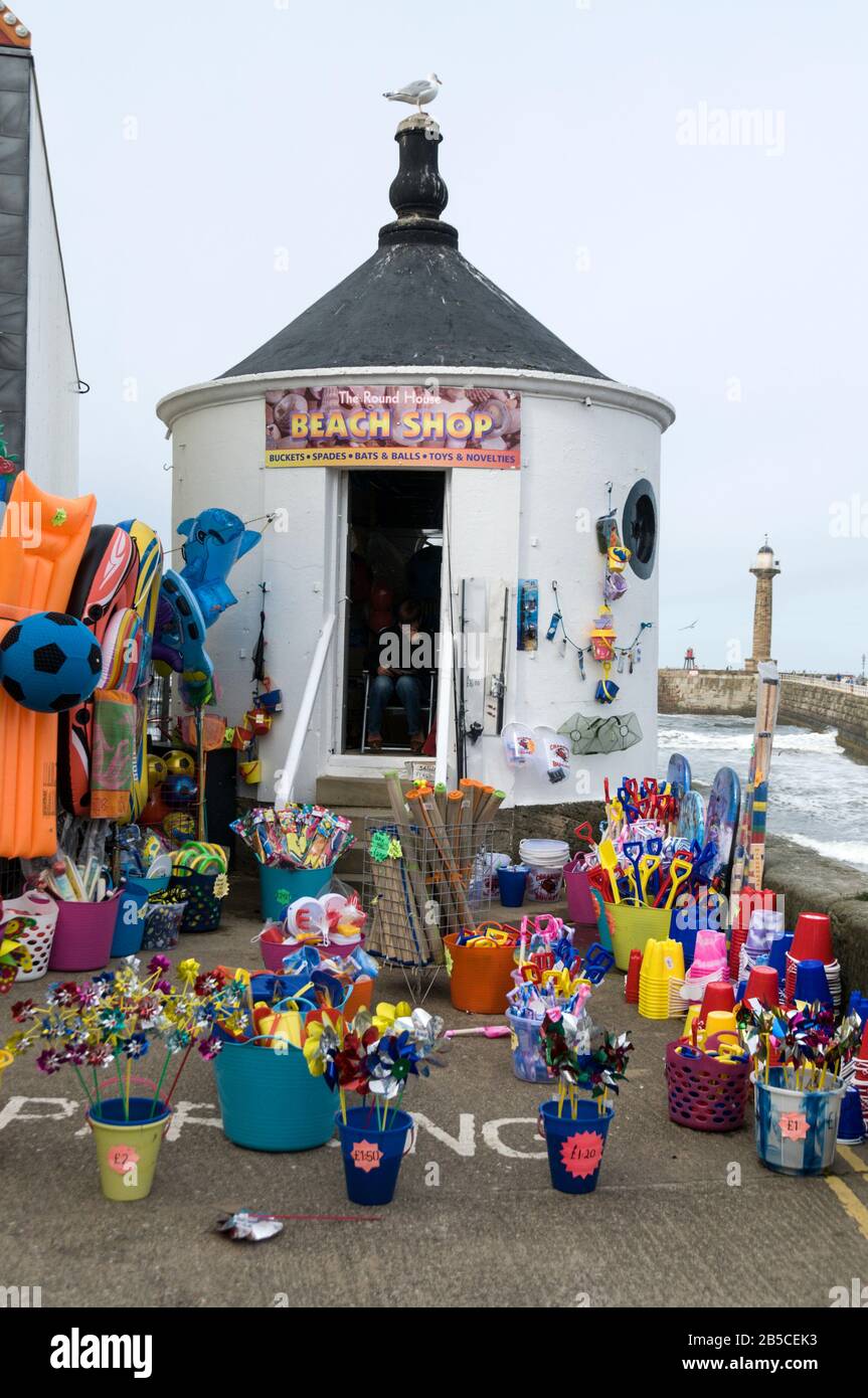Ein Spielzeugladen für Strandkinder, das Strandspielzeug, Eimer und Spaten im historischen Hafen von Whitby an der Ostküste in North Yorkshire, Großbritannien, Wh verkauft Stockfoto