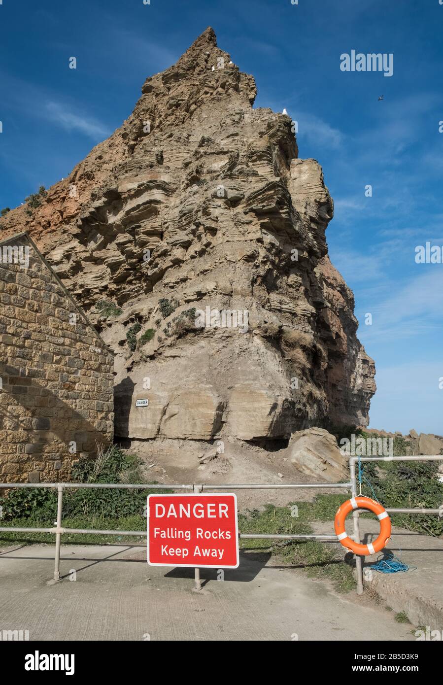 Gefahrenschild für herabfallende Felsen, Staithes, North Yorkshire, Großbritannien Stockfoto