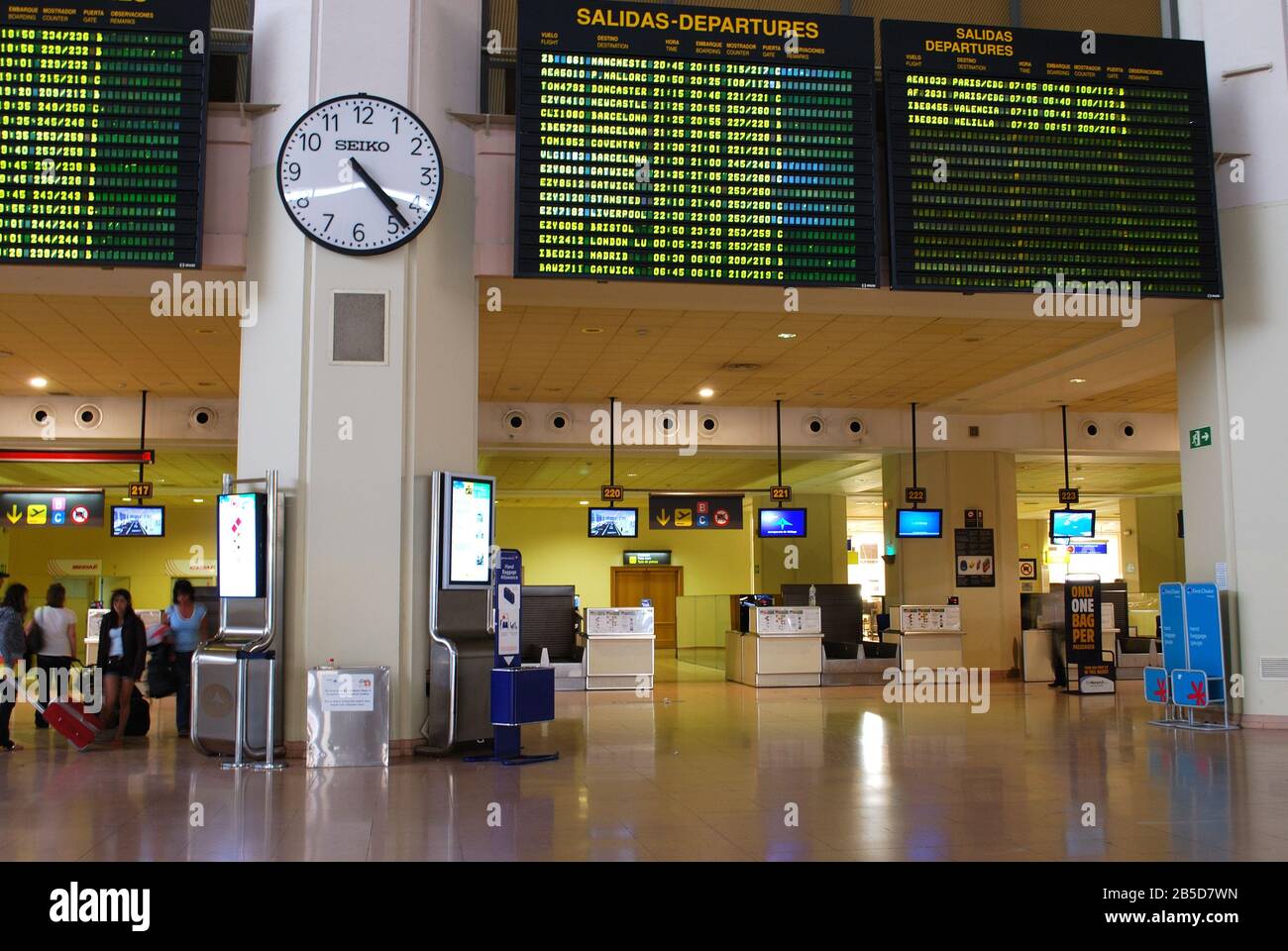 Check-in-Schalter und Fluginformationsbrett im Malaga Airport Terminal, Málaga, Spanien. Stockfoto