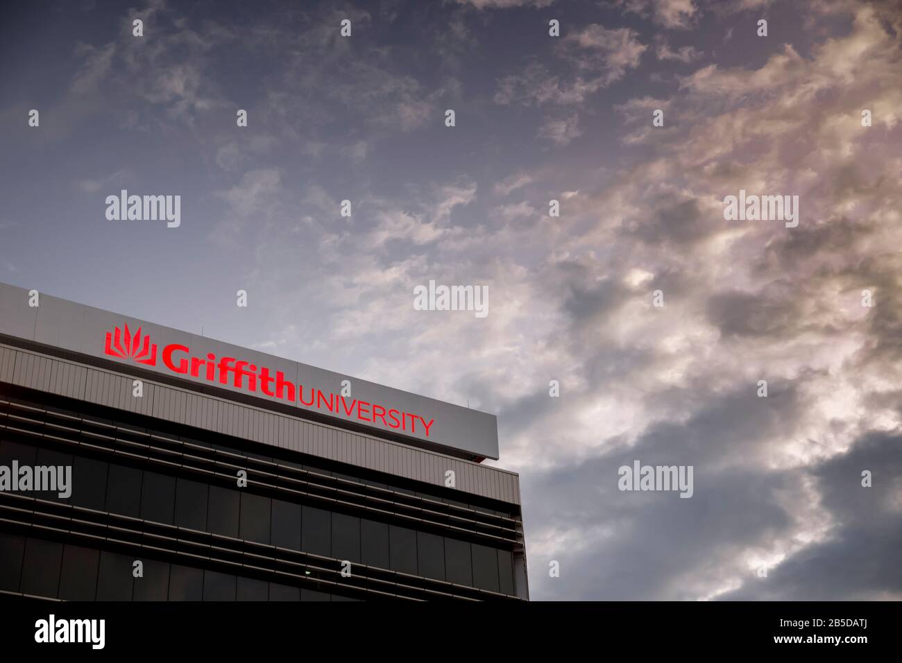 Griffith University Gold Coast Gebäude außen rot leuchtende Beschilderung in der Dämmerung, Australien Stockfoto