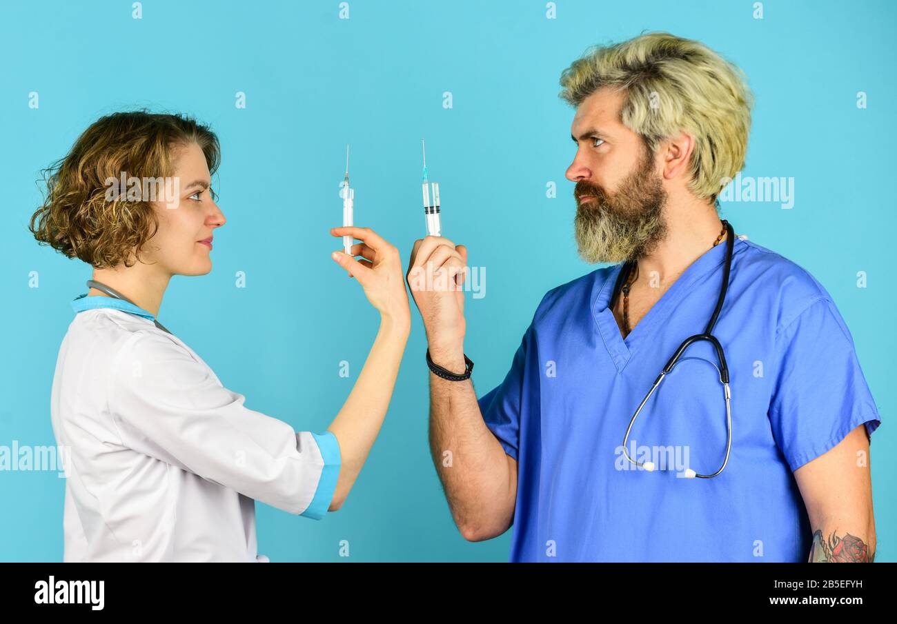 Die Spritze wird von Arzt und Pflegepersonal verwendet. Erfolgreiches Team von Ärzten. Menschen in Uniformen blauer Hintergrund. Medizinisches Personal. Vertrauen Sie unseren Profis. Gesundheitswesen, Teamarbeit und Mitarbeiterkonzept. Stockfoto