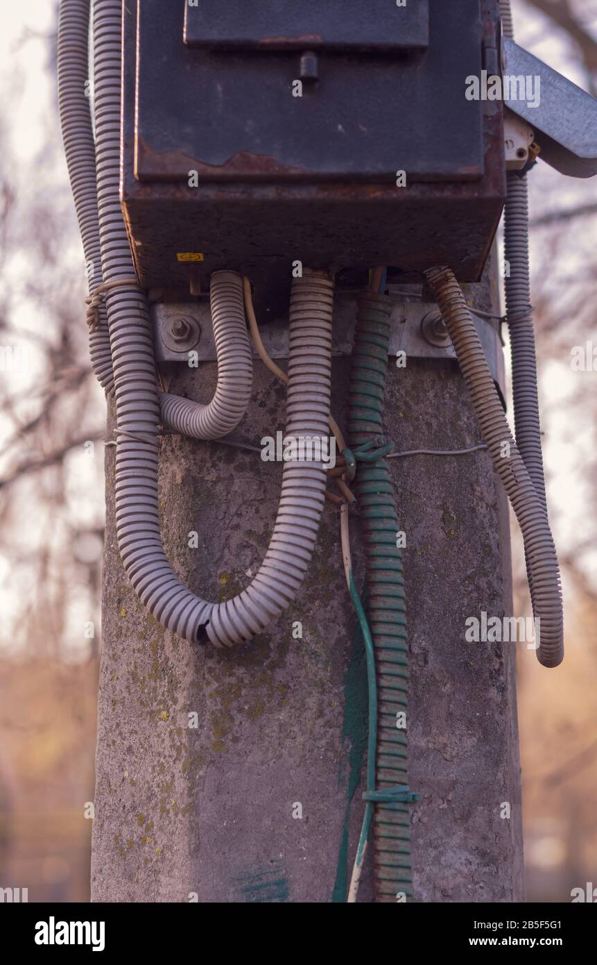 Betonsäule mit einer alten elektrischen Platte. Rostige Metallelektrik an einem Straßenpfosten. Veraltete elektrische Anlagen. Seitenansicht. Selektiver Fokus Stockfoto