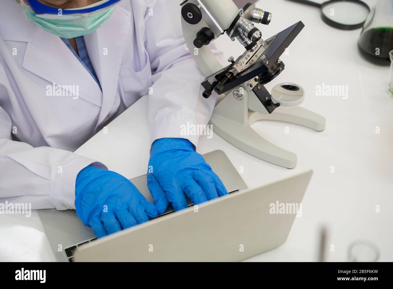 Wissenschaftler untersuchen und untersuchen Mikroskope in Labors, um Impfstoffe gegen Viren zu entwickeln. Stockfoto