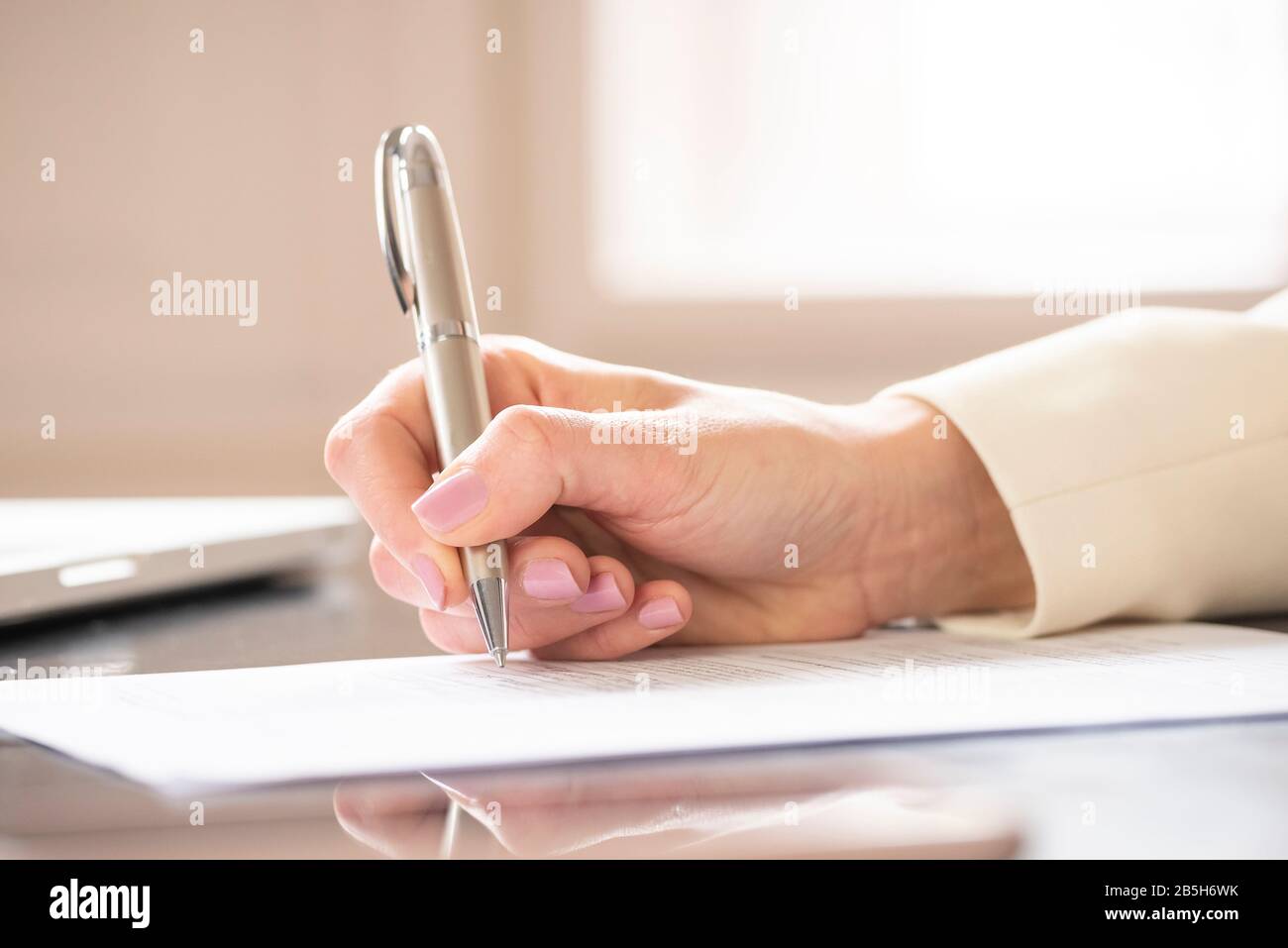 Nahaufnahme der Hand der Geschäftsfrau beim Ausfüllen des Formulars. Stockfoto