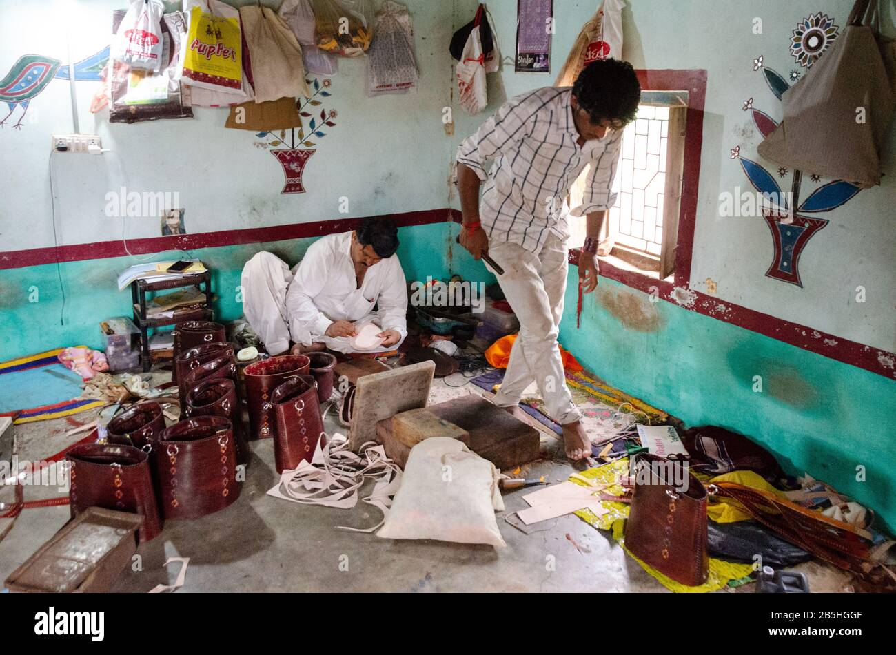 Zwei erfahrene Männer, die in ihrem Haus in Bhirandiyara, Kutch, Gujarat, Indien an Lederprodukten arbeiten Stockfoto