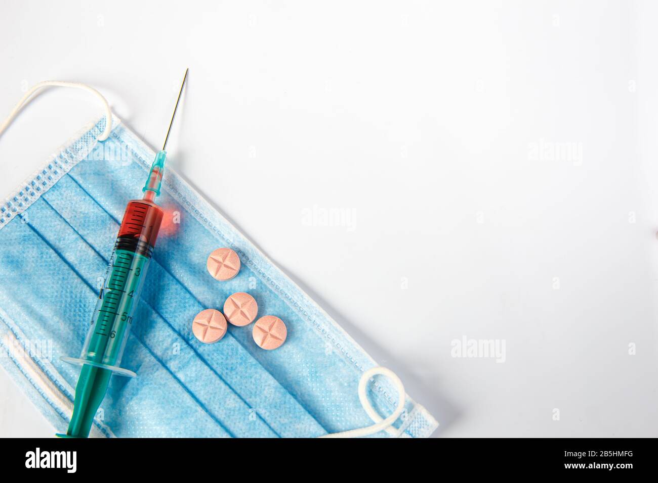 Die Beschriftung medizinische Schutzmaske. Spritze und Pillen. Coronovirus Stockfoto