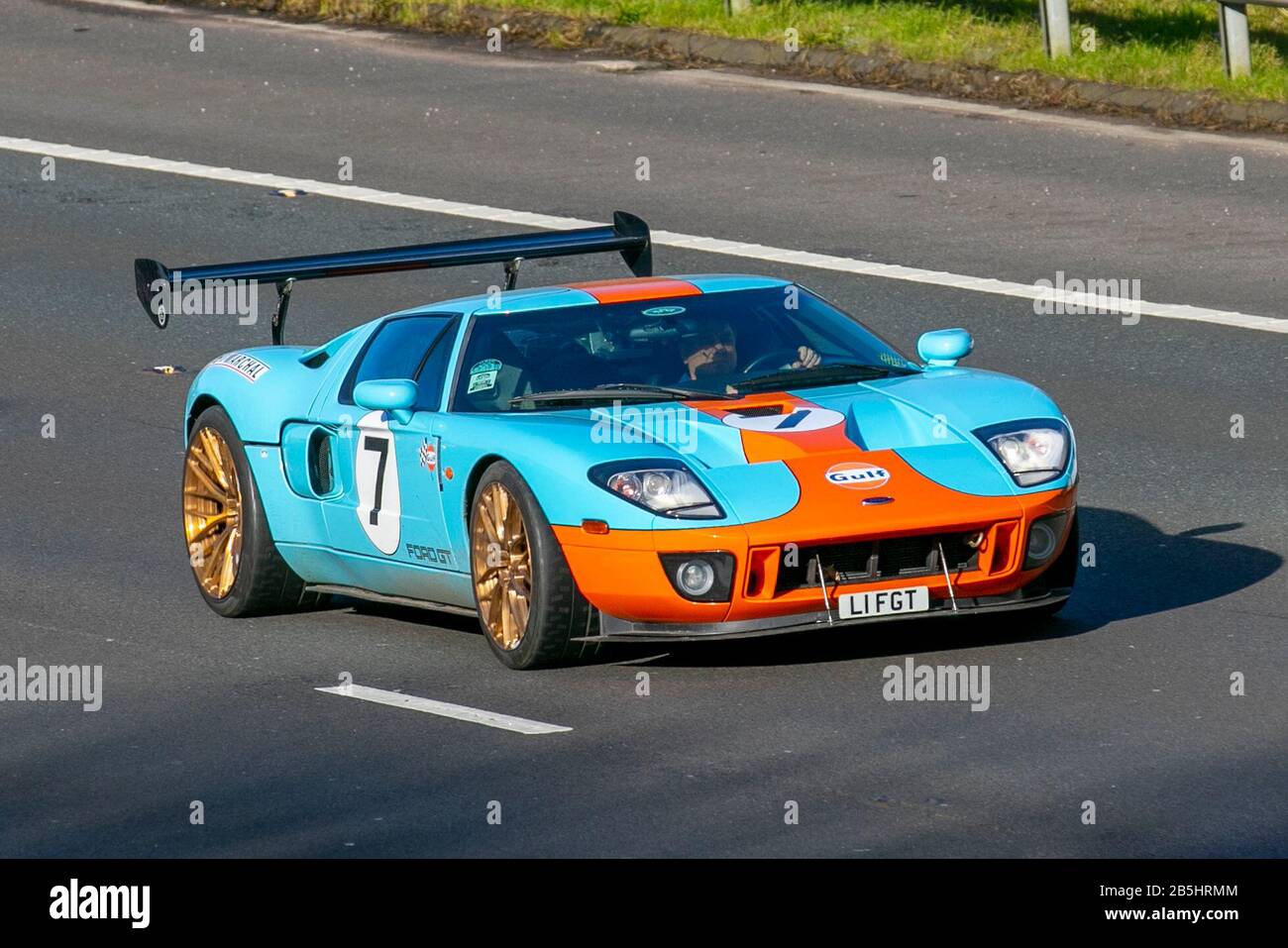 2007 2006 blau orange No,7 Ford GT Heritage Edition Golf gesponserte Rennwagen; UK Fahrzeugverkehr, Transport, moderne Fahrzeuge, Limousinen, Fahrzeuge, Fahrzeuge, Straßen, Motoren, Autofahren auf der Autobahn M6 Stockfoto