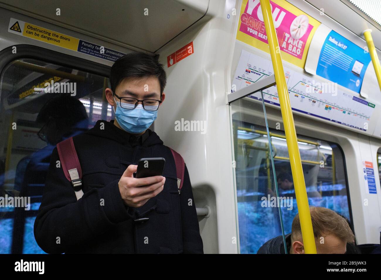 Pendler der Londoner U-Bahn tragen Gesichtsmasken zum Schutz vor Coronavirus Übertragung. Stockfoto