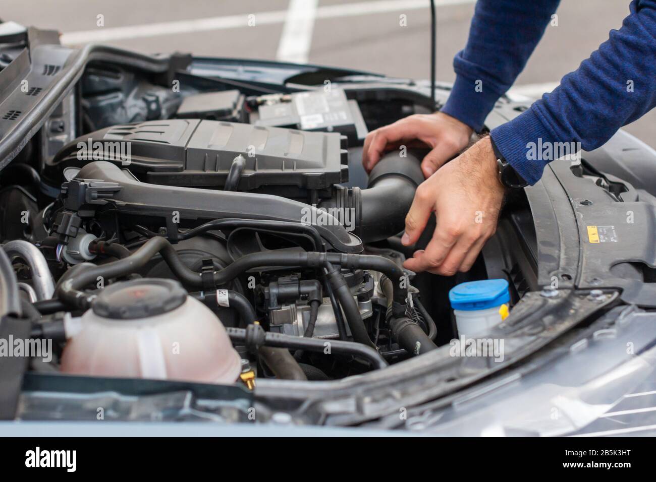 Nahaufnahme des mechanischen Handprüfmotors unter der Haube im zerbrochenen Auto. Reparatur des Fahrzeugkonzepts. Automobilservice Stockfoto