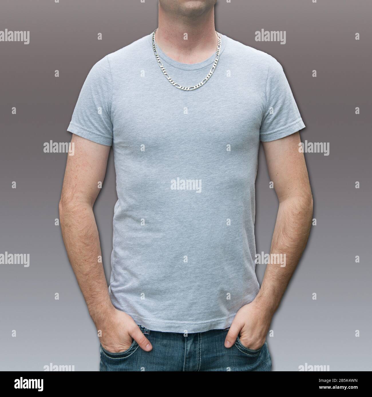 Herren Grau T-Shirt Mockup mit kaukasischem Kerl. Mann mit silberner Kette und viel Platz für Text oder Text auf der Vorderseite des Hemdes. Stockfoto