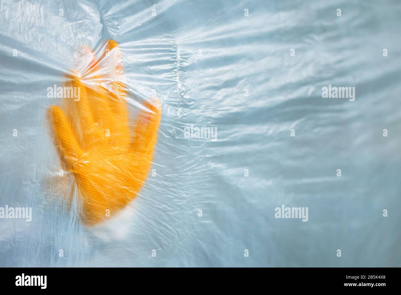 Schutzhandschuh hinter dem Plastikvorhang in Virusquarantäne, medizinischer Fachepidemiologe, der den Virusausbruch bekämpft Stockfoto