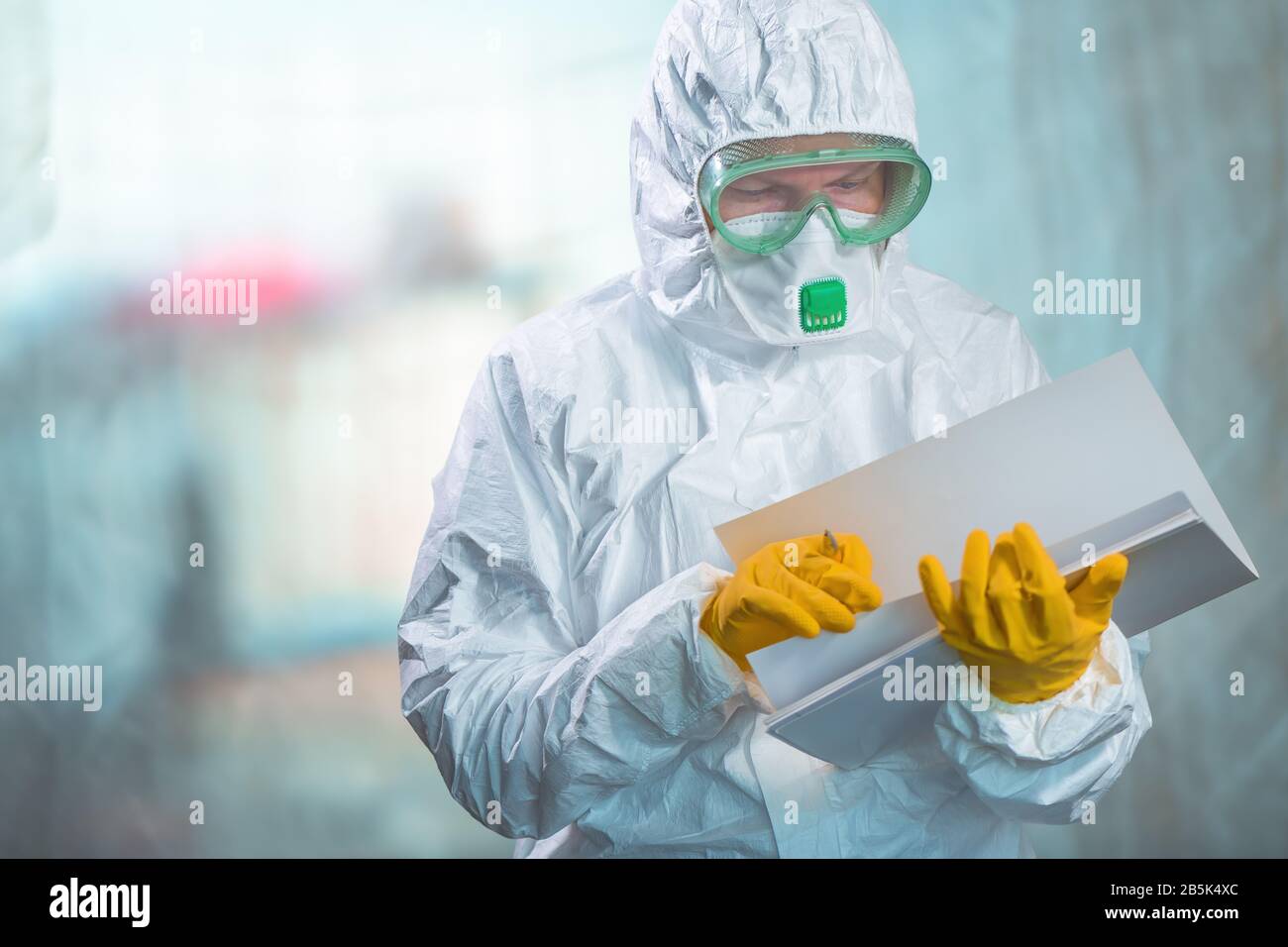 Weibliche Epidemiologin in Schutzkleidung liest Forschungsbericht in Virusquarantäne, medizinische Facharbeit Stockfoto