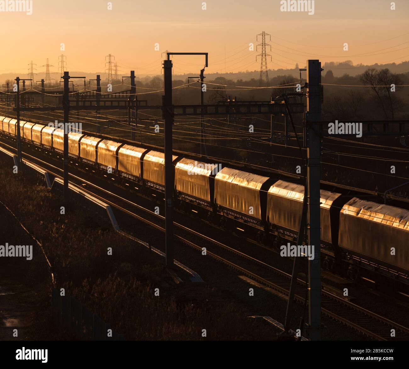 Güterwaggons für den Transport von Kohleglinten in der untergehenden Sonne auf der elektrifizierten Hauptstrecke Great Western South Wales Stockfoto