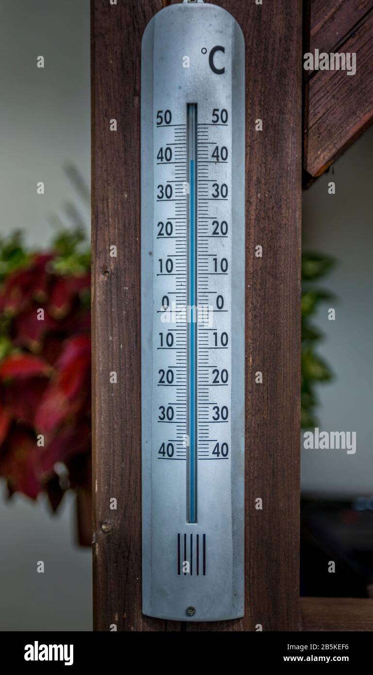 Thermometer in Grad celsius an der Holzwand kalibriert, Konzept von Welttemperatur und Wetter. Stockfoto
