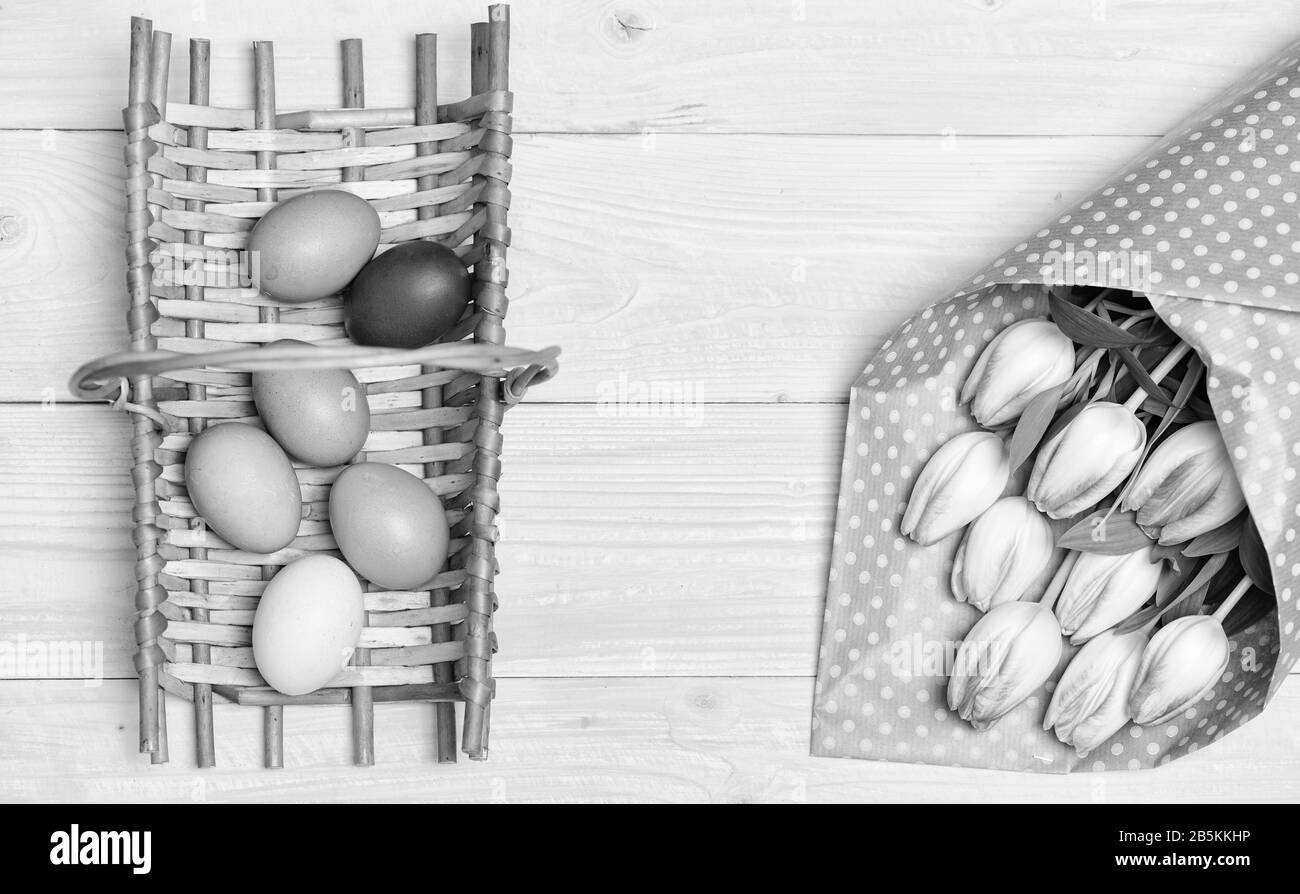 Bunte helle Eier und frisches Bukett Tulpe Blumen auf gelben Hintergrund der Ansicht von oben. Frühling Urlaub. Tradition Feiern Sie das Osterfest. Frohe Ostern Saison. Ostern Eier Symbol. Feder vibes. Ostern steht vor der Tür. Stockfoto