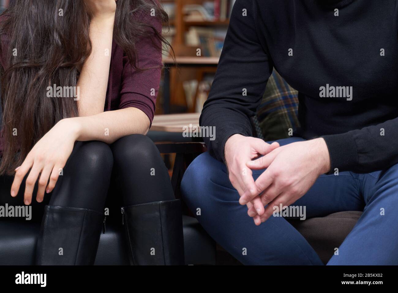 Beschnittenes Bild von Mann und Frau, die sprechen, während sie auf einer Couch sitzen Stockfoto