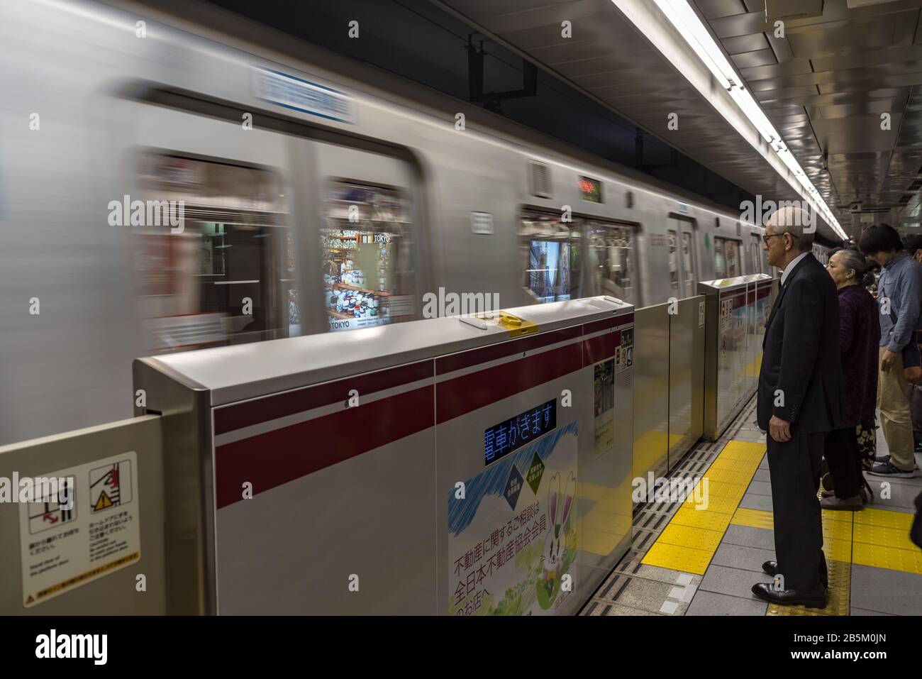 Pendler erwarten die Ankunft der U-Bahn-Station Shinjuku in Tokio Stockfoto