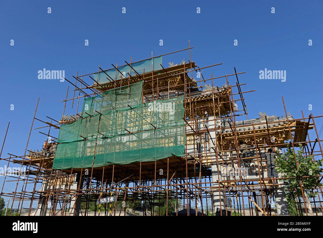 Eingangsbogen im traditionellen Stil im Bau, Gaobeidian, Peking, China, mit Gerüsten bedeckt Stockfoto