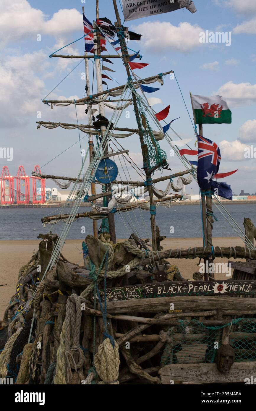 Das Piratenschiff aus schwarzer Perle, das aus Treibholz in der britischen Küstenstadt New Brighton am Ufer des Flusses Mersey gebaut wurde Stockfoto