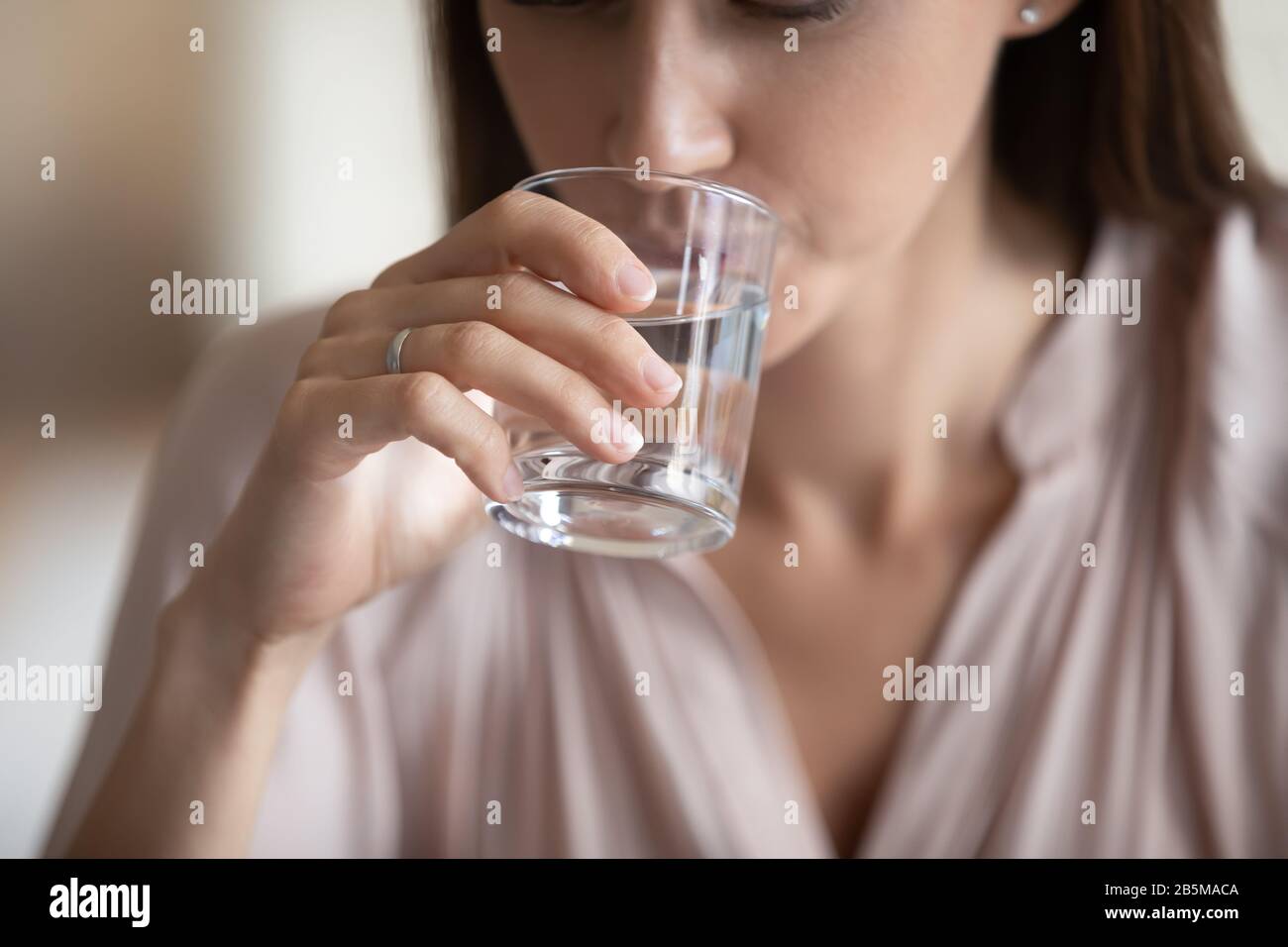 Junge Frau trinkt Glas frisches, noch reines Wasser. Stockfoto