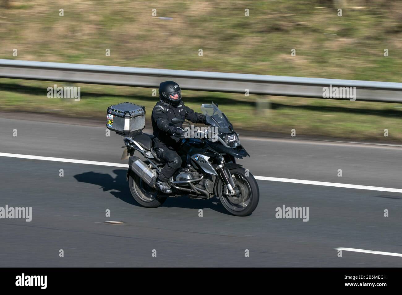 BMW GS Motorrad und Fahrer fahren auf der Autobahn M6 in der Nähe von Preston in Lancashire, Großbritannien Stockfoto