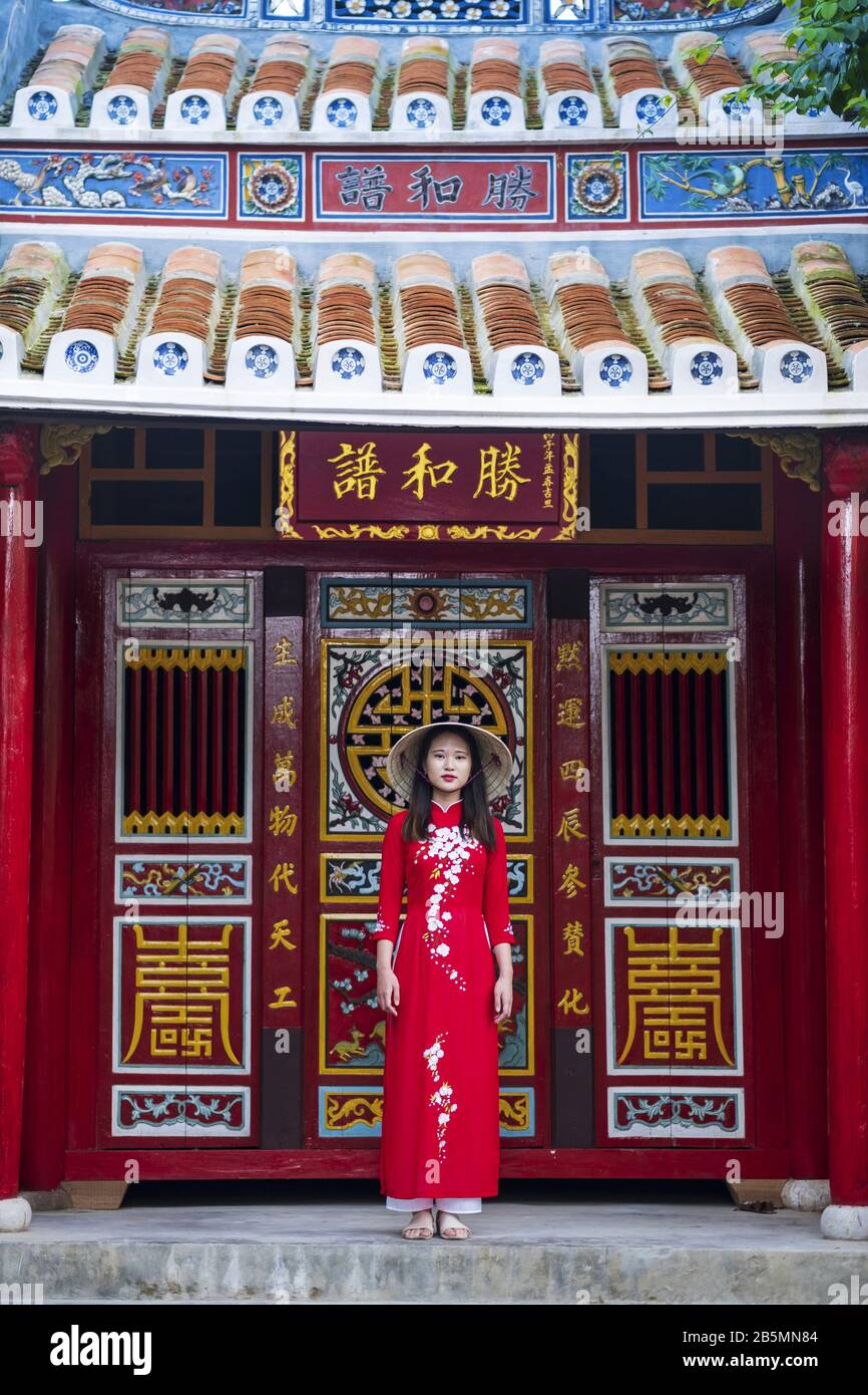 Eine junge Vietnamesin, die ein traditionelles Ao Dai Kleid in den Straßen des alten Hoi An trägt Stockfoto