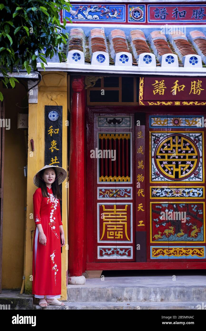 Eine junge Vietnamesin, die ein traditionelles Ao Dai Kleid in den Straßen des alten Hoi An trägt Stockfoto