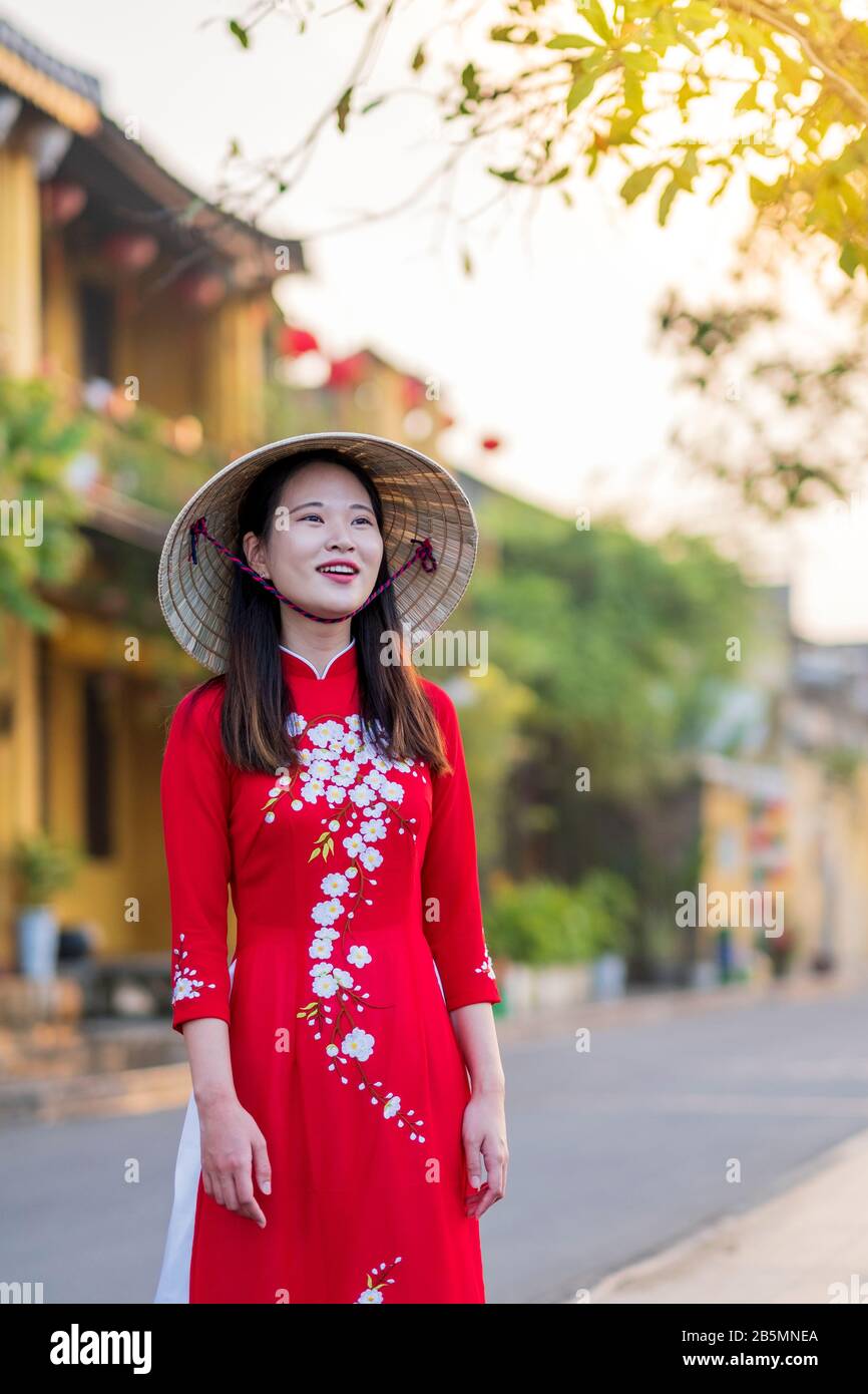 Eine junge Vietnamesin, die ein traditionelles Ao Dai Kleid in den Straßen des alten Hoi An trägt Stockfoto