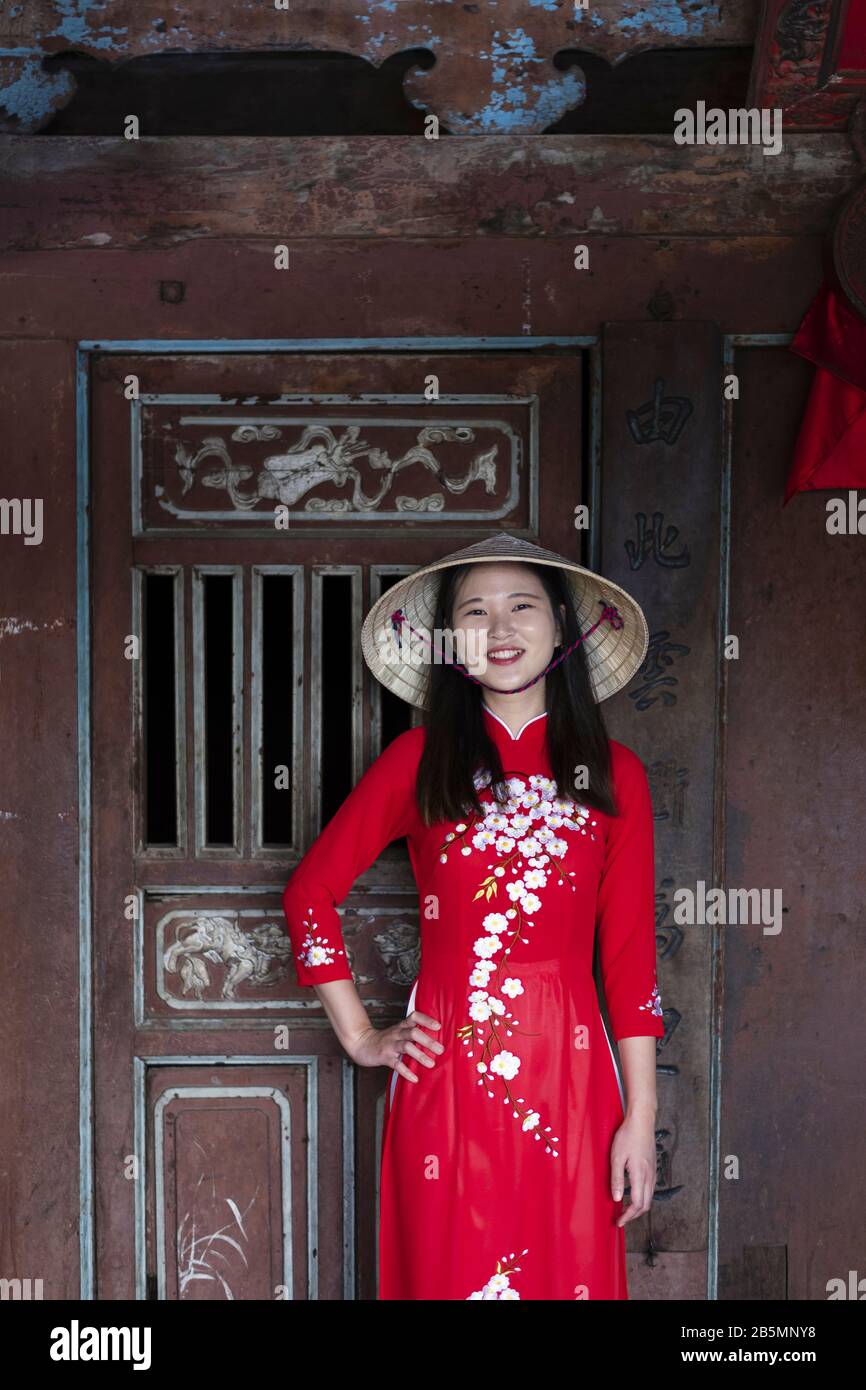 Eine junge Vietnamesin, die ein traditionelles Ao Dai Kleid in den Straßen des alten Hoi An trägt Stockfoto