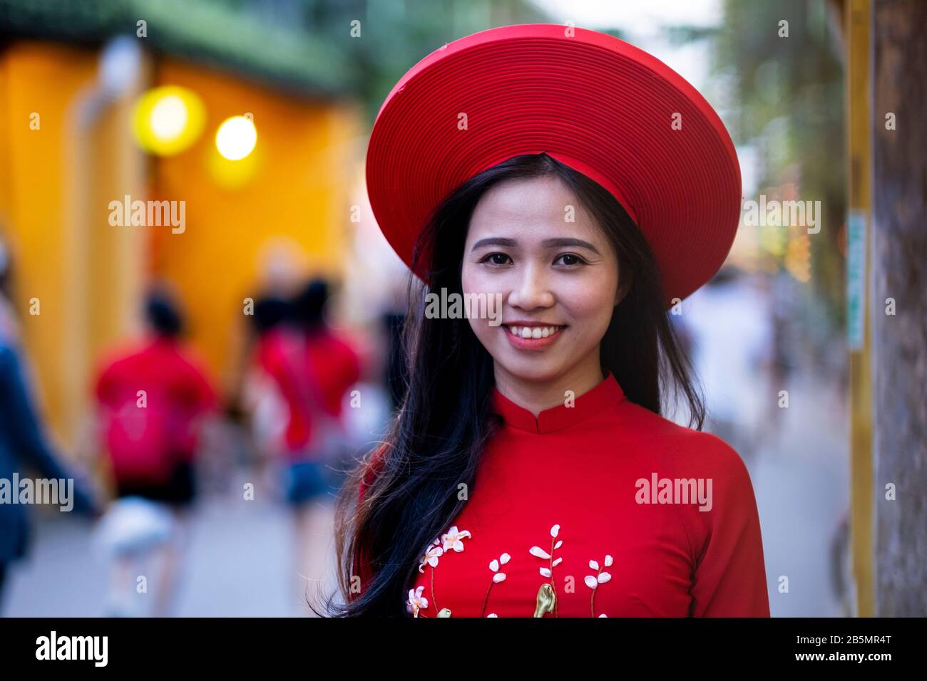 Eine junge Vietnamesin, die ein traditionelles rotes Kleid (Ao Dai) trägt Stockfoto