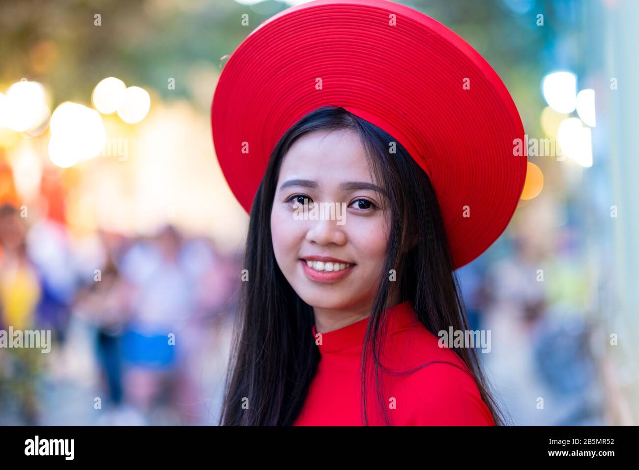Eine junge Vietnamesin, die ein traditionelles rotes Kleid (Ao Dai) trägt Stockfoto