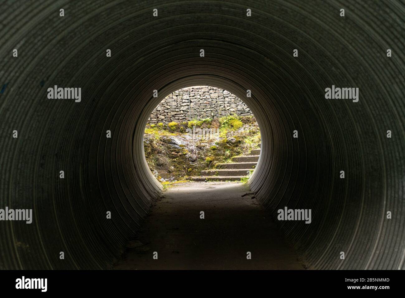 Gehen Sie durch einen dunklen Tunnel, während Sie den West Highland Way in Schottland wandern. Stockfoto