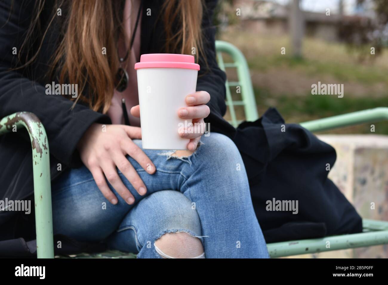 Weibliche Hand für wiederverwendbaren Kaffeebecher. Nehmen Sie Ihren Kaffee zum Mitnehmen. Stockfoto