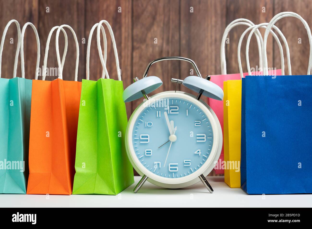 Wecker und bunte Einkaufstaschen Stockfoto