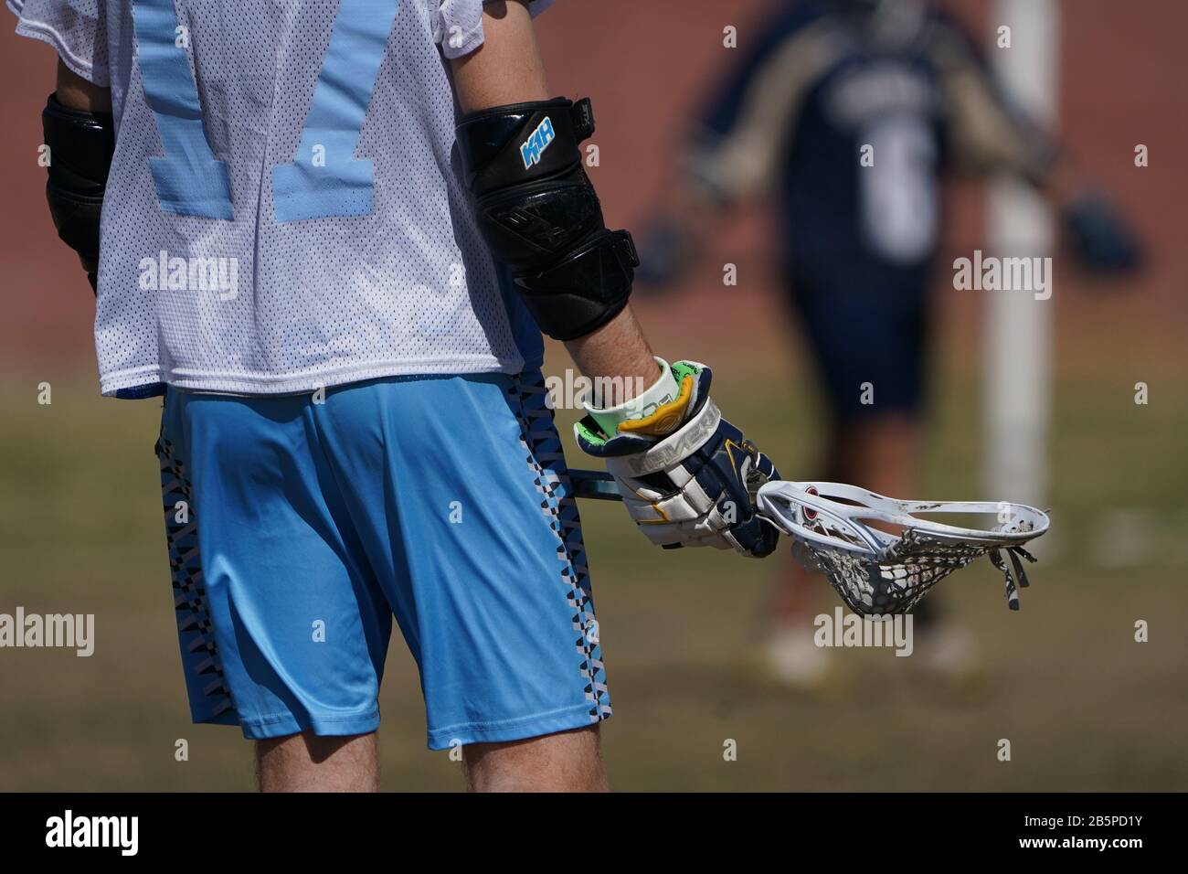 Ein knapper Schuss eines Lacrossespielers, der seinen Stick einsatzbereit hält. Stockfoto