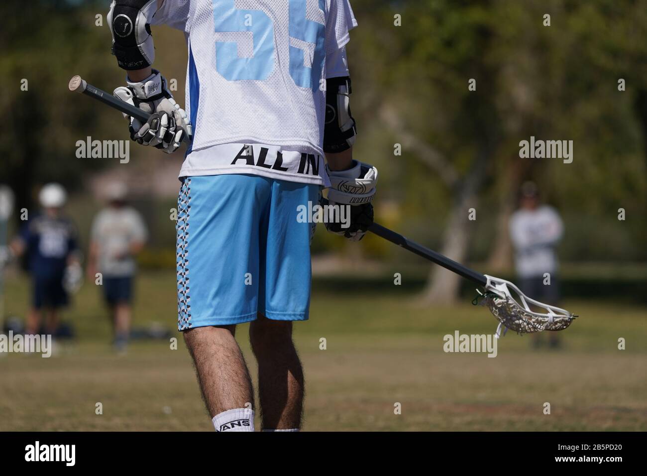 Ein knapper Schuss eines Lacrossespielers, der seinen Stick einsatzbereit hält. Stockfoto