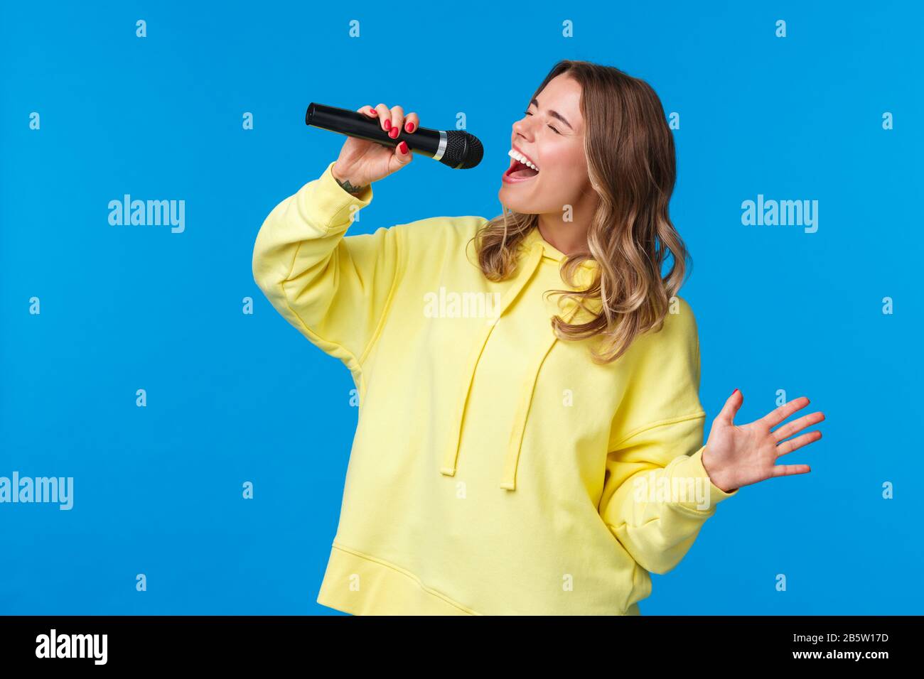 Smiling Blonde Girl Singing Microphone Stockfotos und -bilder Kaufen - Alamy