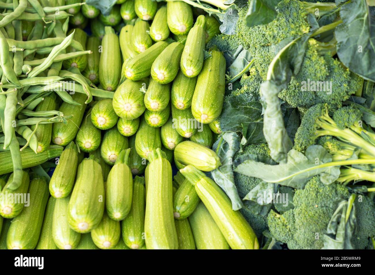 Ein Haufen exotisches Gemüse, Zucchini, Broccoli und Grean-Bohnen in einem Lebensmittelgeschäft Stockfoto