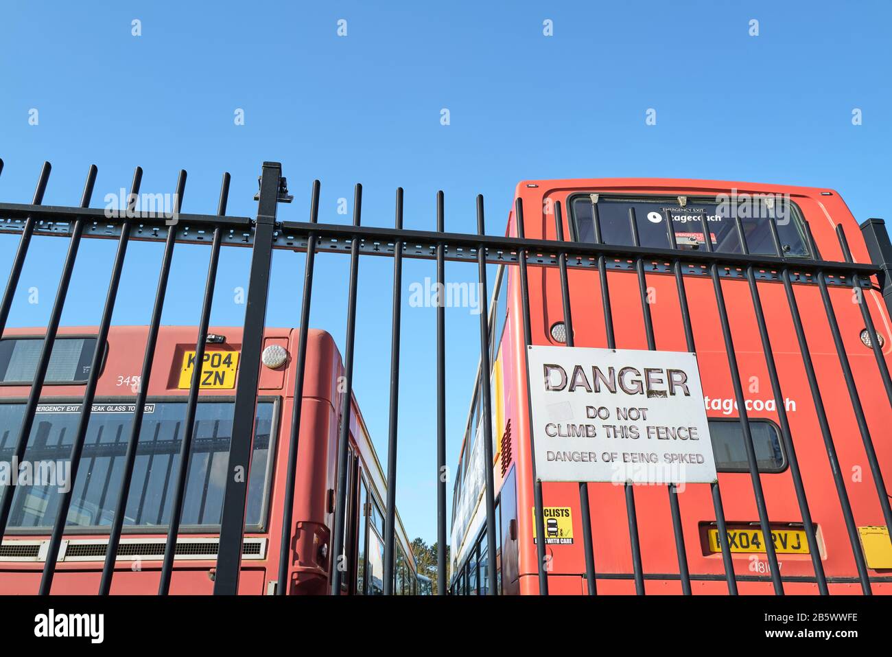 Gefahrenhinweis am Zaun des Depots Stagecoach in Corby, Northamptonshire, England. Stockfoto