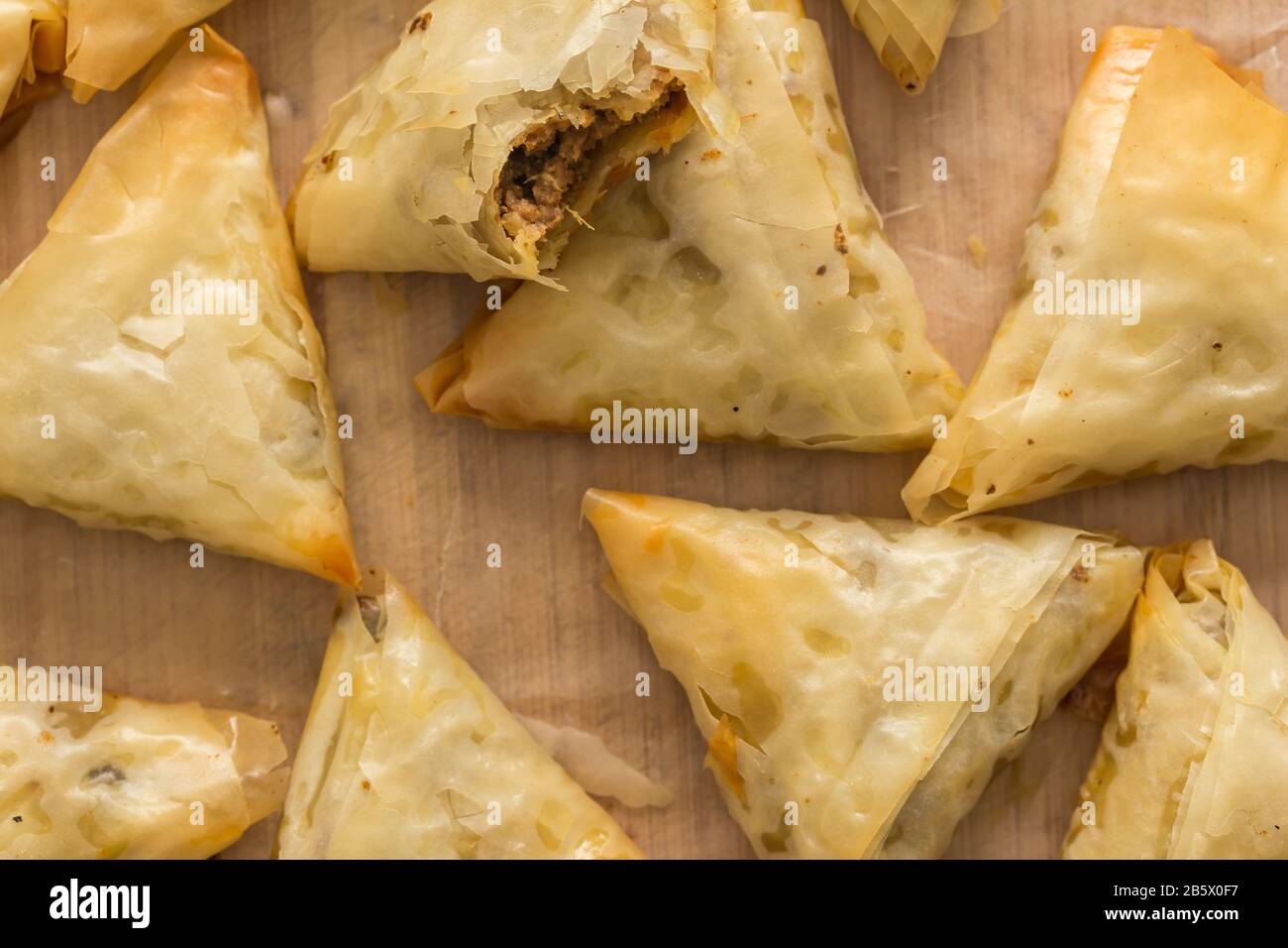 Backofenbackene Phyllo-Gebäck-Samosas mit würzigem Fleisch - Draufsicht Foto von Vorspeisen Snacks auf Holzbrett Stockfoto