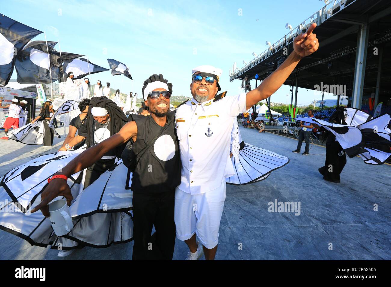 Port OF SPAIN, TRINIDAD - 25. FEBRUAR: Der Tonkünstler Machel Montano (R) tritt mit Maskern in der von Peter Minshall entworfenen und produzierten Band Mas Pieta auf Stockfoto