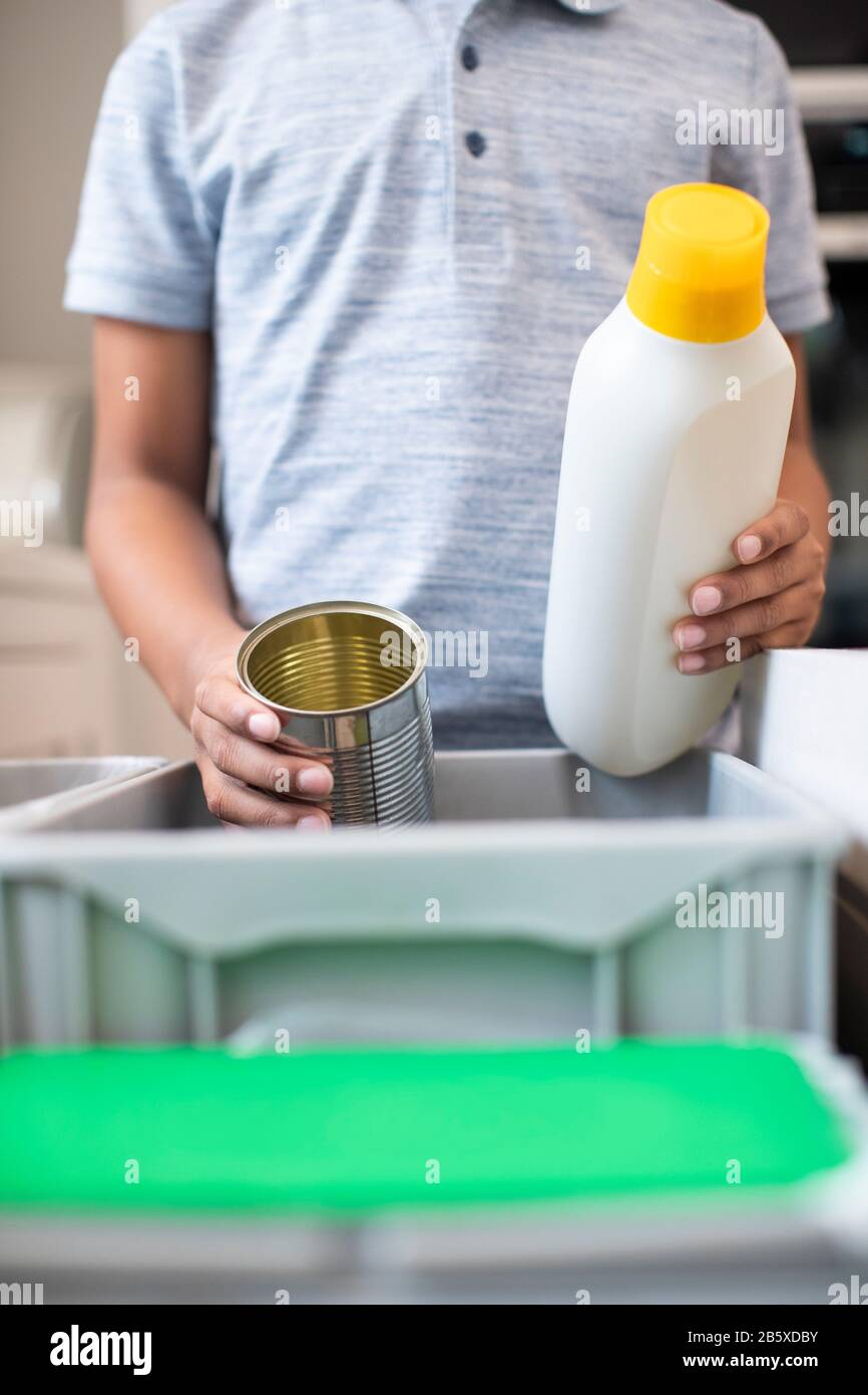 Nahaufnahme Von Boy Sortieren Recycling In Kitchen Bin Zu Hause Stockfoto