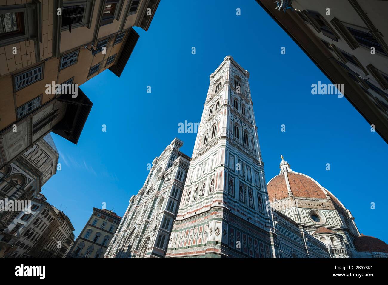 Dramatischer blauer Himmelsblick auf die Piazza del Duomo mit Giottos Glockenturm, der über der Kuppel des Doms in Florenz, Italien, steht Stockfoto