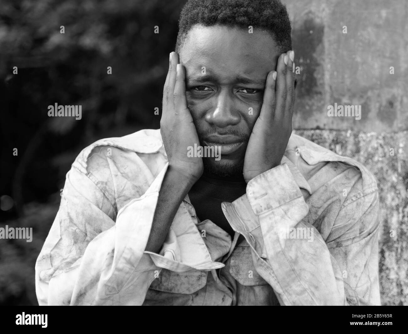 Gesicht eines jungen obdachlosen Afrikaners, der in Schwarzweiß depressiv aussieht Stockfoto