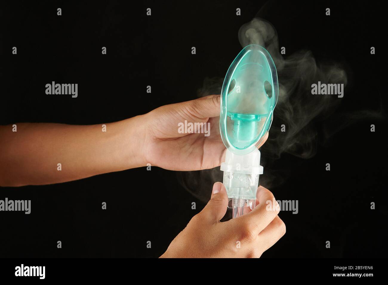 Nahaufnahme der Arbeitsmaske des Inhalators mit auf schwarzem Hintergrund isoliertem Rauch Stockfoto