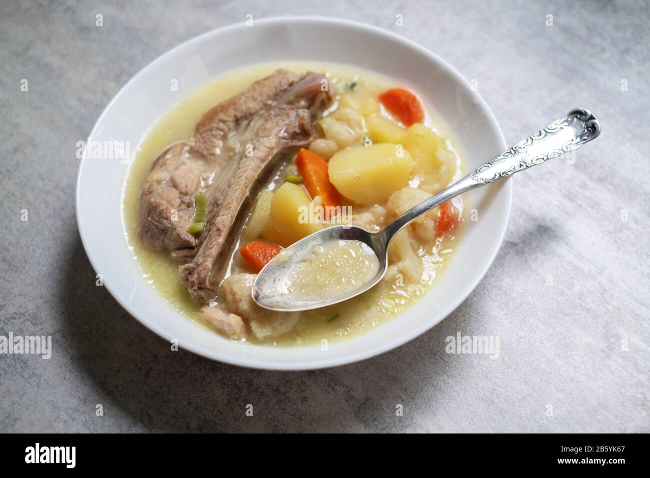 Suppe mit Kartoffel- und Schweinefleischfleisch. Lebensmittelfotografie Stockfoto